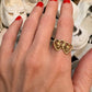 interlocking double heart 14K gold ring that has baby doll heads in gold int he center