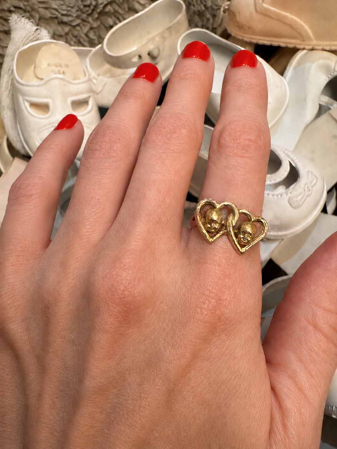 interlocking double heart 14K gold ring that has baby doll heads in gold int he center