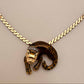 A gold chain necklace featuring a leopard pendant with a gold and black spotted pattern and a small diamond crown, displayed on a neutral beige background.