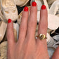 One of a kind 14K gold vintage heart ring with hand sculpted baby head by Anomaly Relic, photographed among antique baby shoes on a young woman's hand