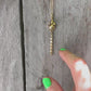 A 14k gold rat pendant necklace featuring a small heart-shaped chain tail with a dangling, articulated heart-link chain
