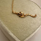 A 14k gold rat pendant necklace featuring a small heart-shaped chain tail with a dangling, articulated heart-link chain